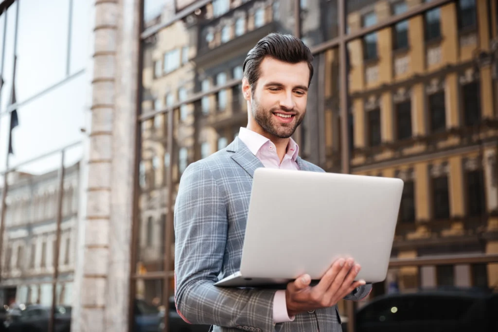 GMB expert in model town working on laptop outside office.